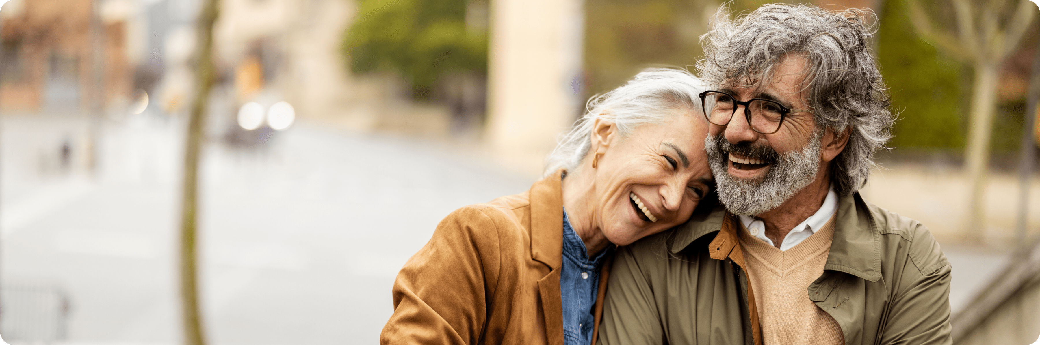 man and woman smiling on bench
