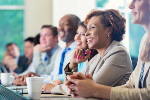 smiling female with a group of coworkers in a board room meeting